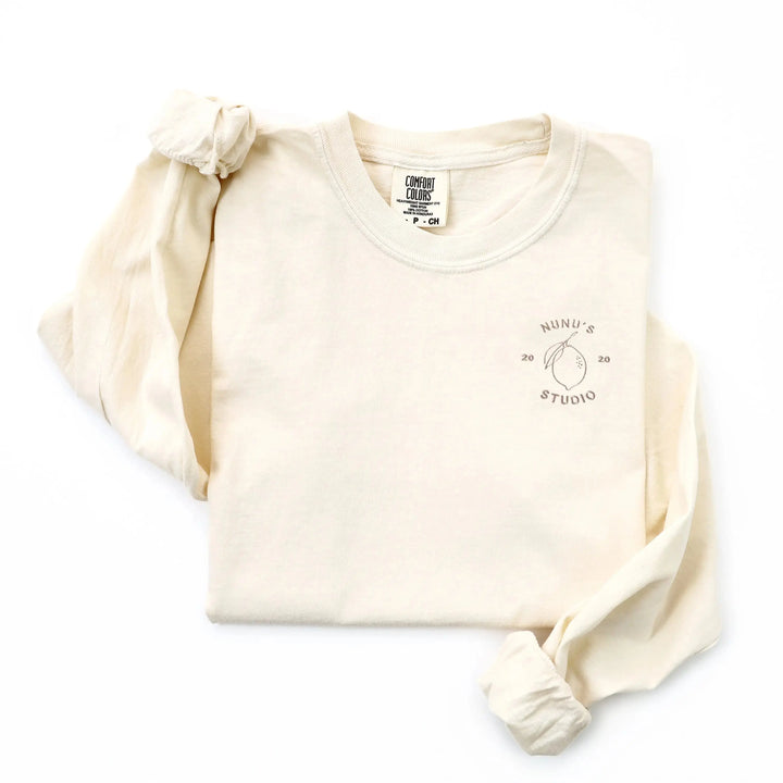ivory colored long sleeve comfort colors t-shirt with tan colored logo embroidery